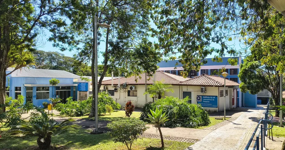 Pátio arborizado de campus universitário com prédios baixos